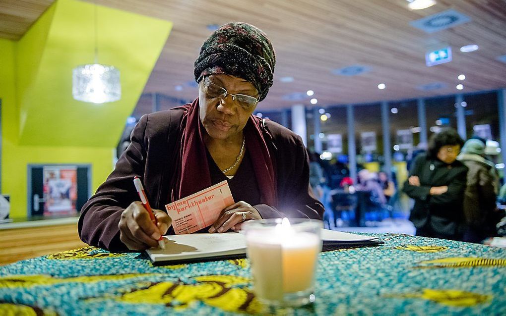 Een vrouw tekent het condoleanceregister in de Bijlmer. Foto ANP