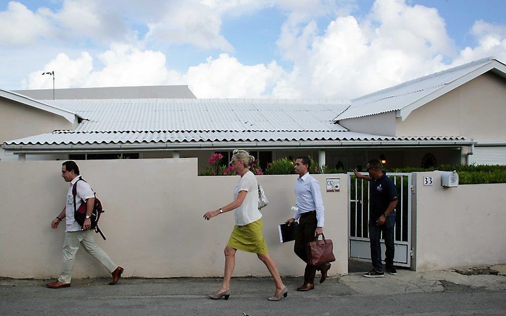 Medewerkers van de belastingdienst en politie verlaten het huis van voormalig premier van Curaçao Gerrit Schotte op Curaçao.  Foto ANP