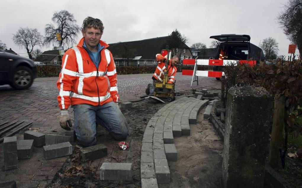 Klaas Dunnink tikte gisteren de laatste stenen in de Oude Rijksweg in Staphorst. De stratenmaker en zijn medewerkers hebben er zeven kilometer opzitten. beeld Eelco Kuiken