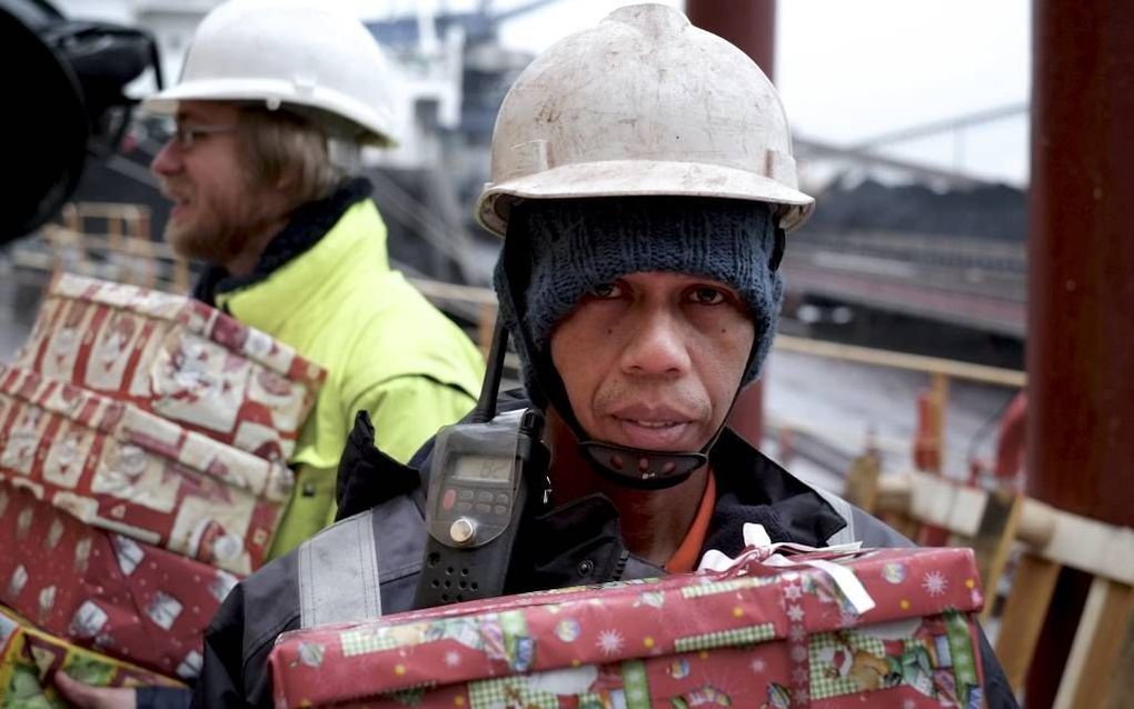 Felix Henrichs (linksachter) brengt kerstpakketten op schepen in Rotterdam en vertelt de bemanning over het Evangelie. Beeld Sjaak Verboom