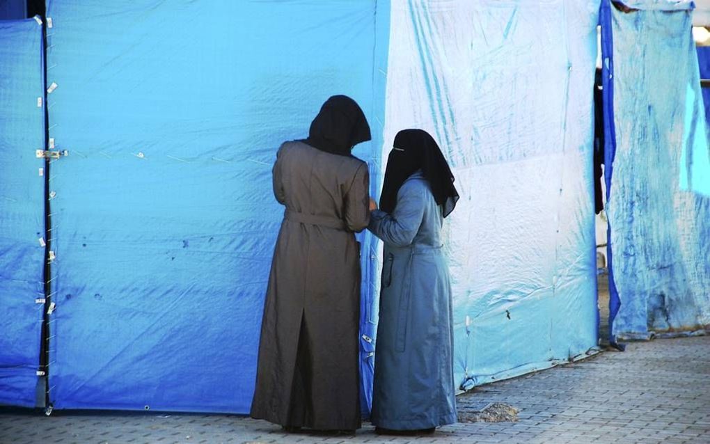 Twee dames in burka smoezen met elkaar in het vluchtelingenkamp in Kilis. beeld Gerard ten Voorde