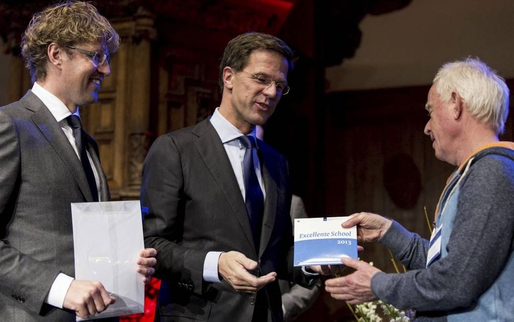 Staatssecretaris van Onderwijs Dekker (l.) en premier Rutte reikten maandag 76 keer het predicaat ”excellente school” uit in de Nieuwe Kerk in Den Haag. Het Zeeuwse Calvijn College werd drie keer gelauwerd. beeld ANP