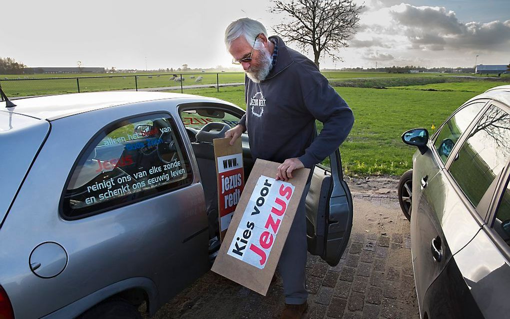 Joop van Ooijen haalt wat campagnemateriaal uit zijn auto voor zijn huis in Giessenburg. Zijn partij ”Jezus leeft" wil in verschillende plaatsen meedoen aan de komende gemeenteraadsverkiezingen. beeld ANP