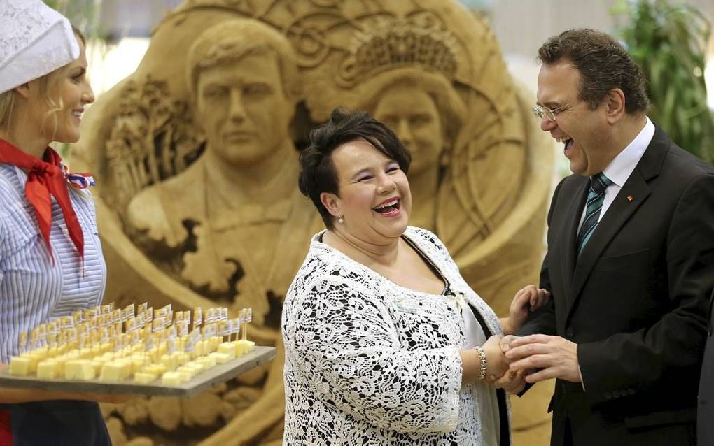 Een vrolijk moment in het Nederlandse paviljoen op de Grüne Woche in Berlijn: staatssecretaris Dijksma begroet de Duitse minister van Landbouw, Friedrich (r.), terwijl Frau Antje klaar staat met de traditionele blokjes kaas. beeld EPA