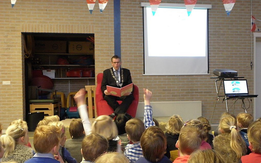 Burgemeester A. Baars van gemeente Ermelo leest de kleuters van de Augustinusschool in zijn woonplaats voor. Vandaag deden tientallen bekende Nederlanders hetzelfde op kinderdagverblijven, crèches, basisscholen en openbare bibliotheken in het kader van He