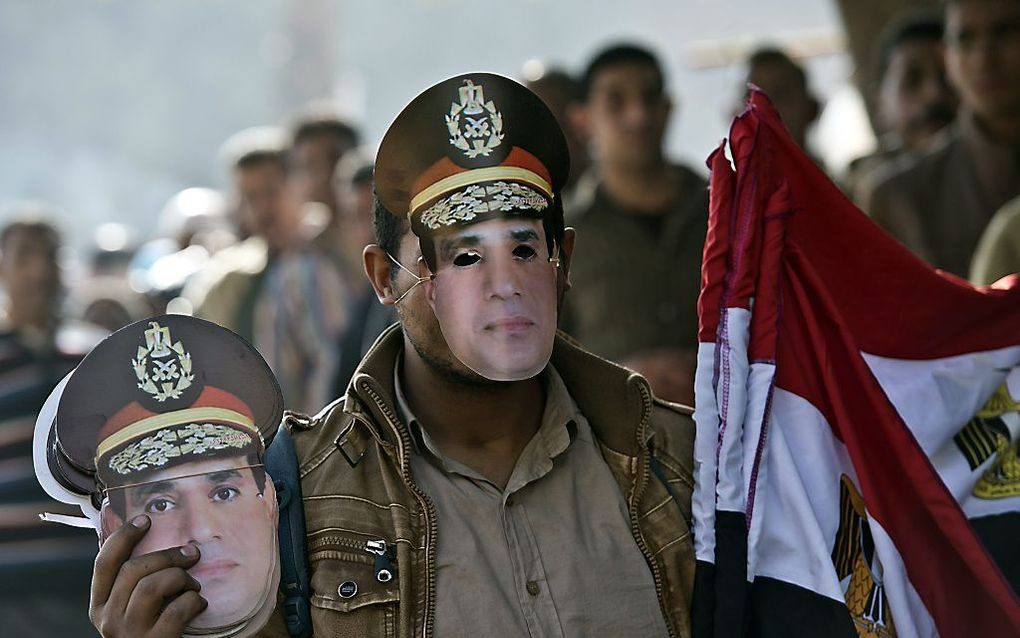 Een straatverkoper met maskers van al-Sisi. Foto EPA