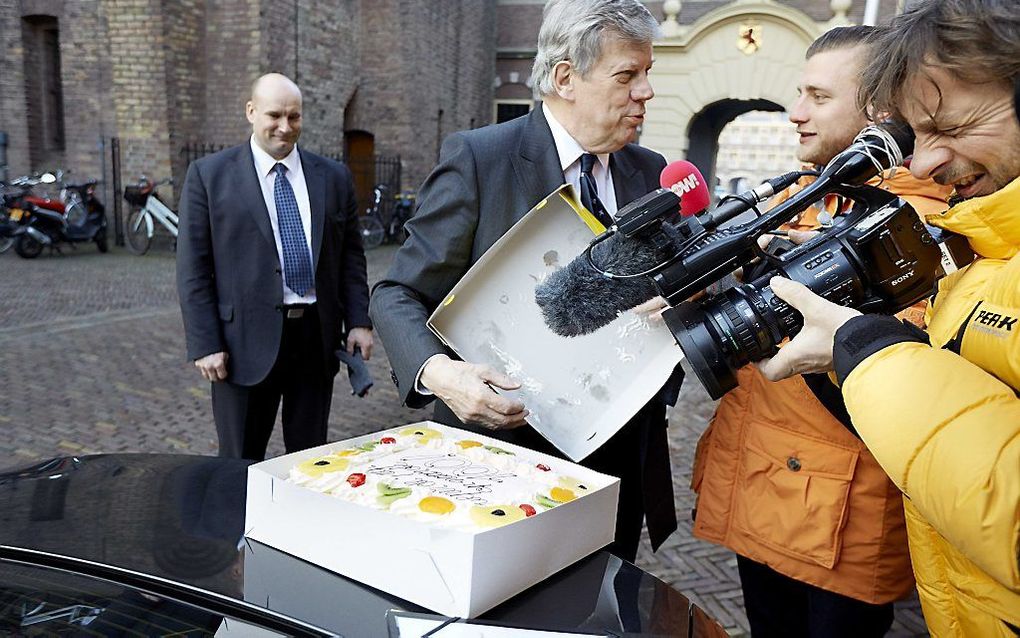 Minister van Veiligheid en Justitie Ivo Opstelten krijgt een taart van PowNews voor zijn 70ste verjaardag, bij aankomst voor de wekelijkse ministerraad op het Binnenhof. beeld ANP