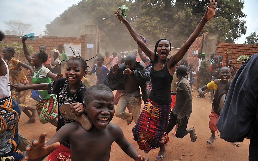 Uitgelaten kinderen in Bangui rennen achter de auto aan met daarin president Catherine Samba-Panza van de Centraal-Afrikaanse Republiek. Foto AFP