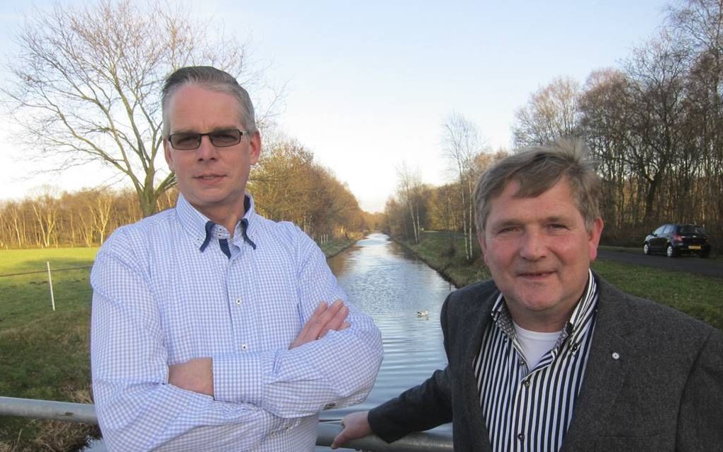 Henk Morsink (links) en Gerrits Engberts van waterschap Vechtstromen staan tussen Westerhaar en Vriezenveen op de brug over de Verbindingsleiding, zoals dit water heet. beeld Gerrit Dannenberg