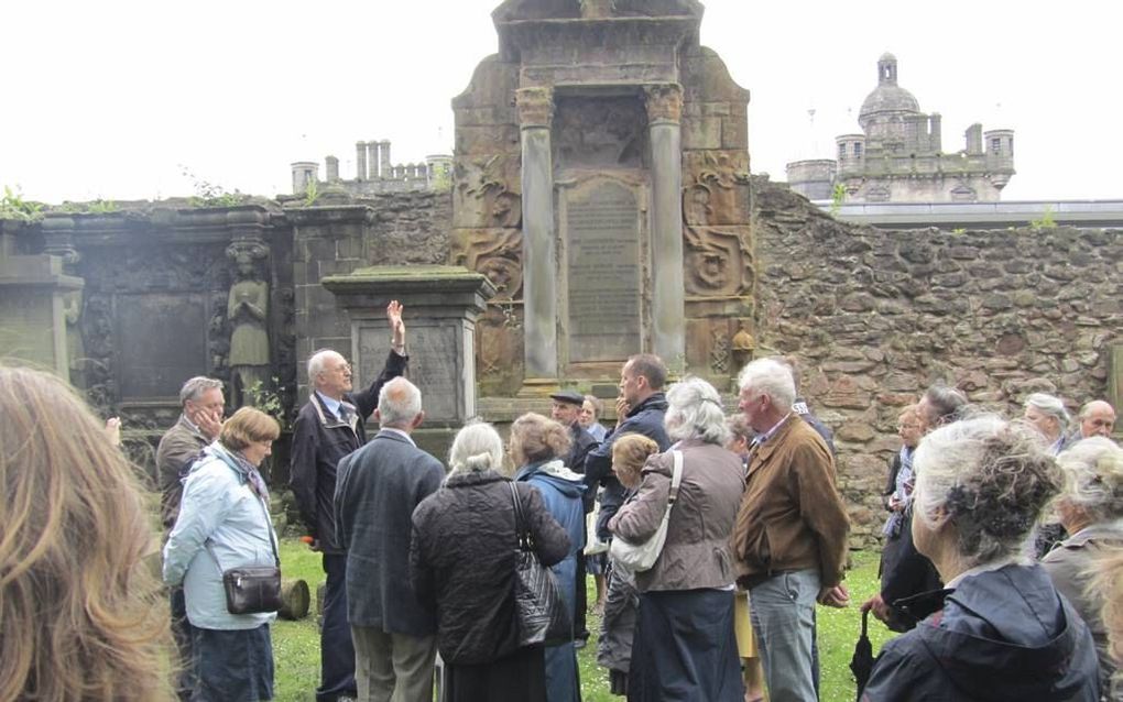 De deelnemers aan kerkhistorische reizen vormen vanwege hun gezamenlijke interesse vaak een hechte groep. Foto: kerkhistoricus en reisorganisator L. J. van Valen met een groep op de Greyfriarsbegraafplaats in Edinburgh, een plek die een grote rol speelde 