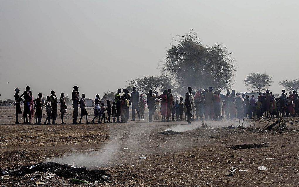 Zuid-Sudanezen, vooral uit Bor, staan in een rij voor een tijdelijk opvangkamp in Mingkaman om geregistreerd en opgenomen te worden. Tijdens een massamoord in Bor werd ook een aantal vrouwelijke kerkenwerkers vermoord. Beeld AFP