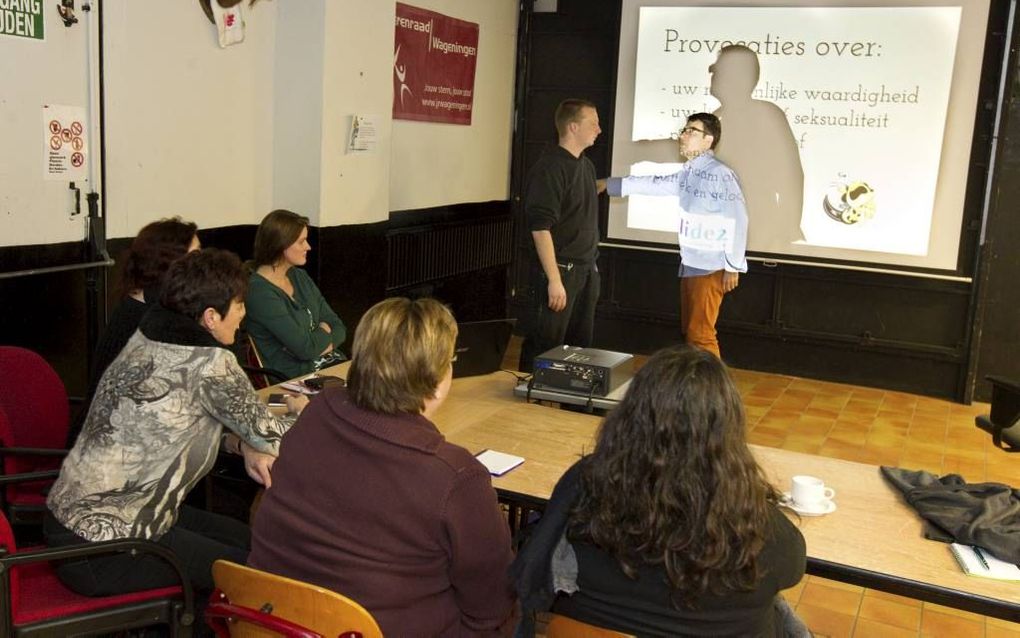 Jongerenwerker Alex Looijen (staande links) van welzijnsorganisatie Solidez in Wageningen tijdens een rollenspel in gesprek met een bezoeker van de cursus ”Omgaan met hangjongeren”. De cursus trok dinsdagavond een handjevol Wageningers, vooral leden van z