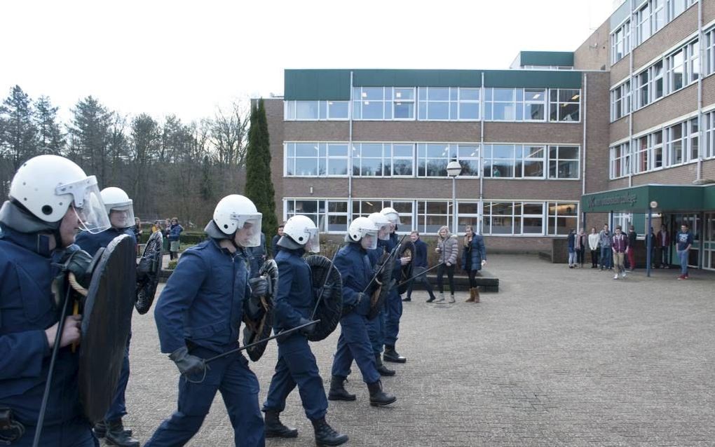 Gekleed in ME-pakken bestormden acht leden van de jongerenorganisatie van de SGP gisteren het schoolplein van het Van Lodenstein- en het Hoornbeeckcollege in Amersfoort. beeld Rick van de Waerdt