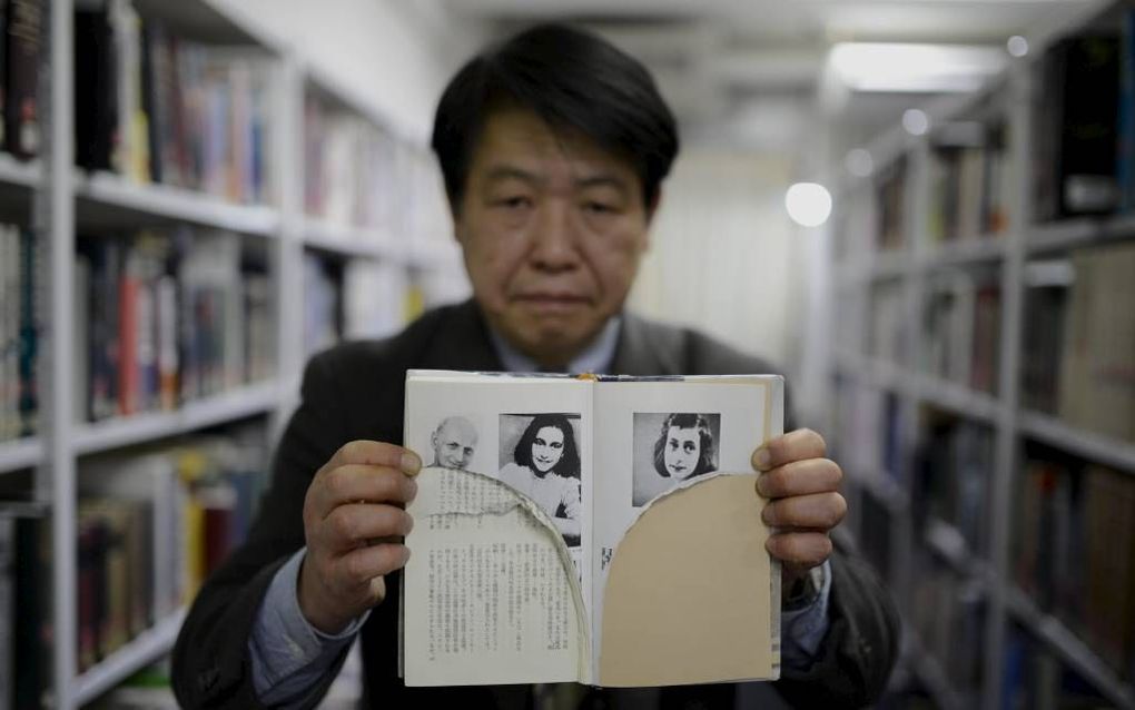 Bibliothecaris Kotaro Fujimaki uit Tokio toonde vorige week enkele toegetakelde exemplaren van het ”Dagboek van Anne Frank”. Honderden dagboeken van het Joodse meisje bleken in diverse bibliotheken in Tokio moedwillig te zijn beschadigd. beeld EPA