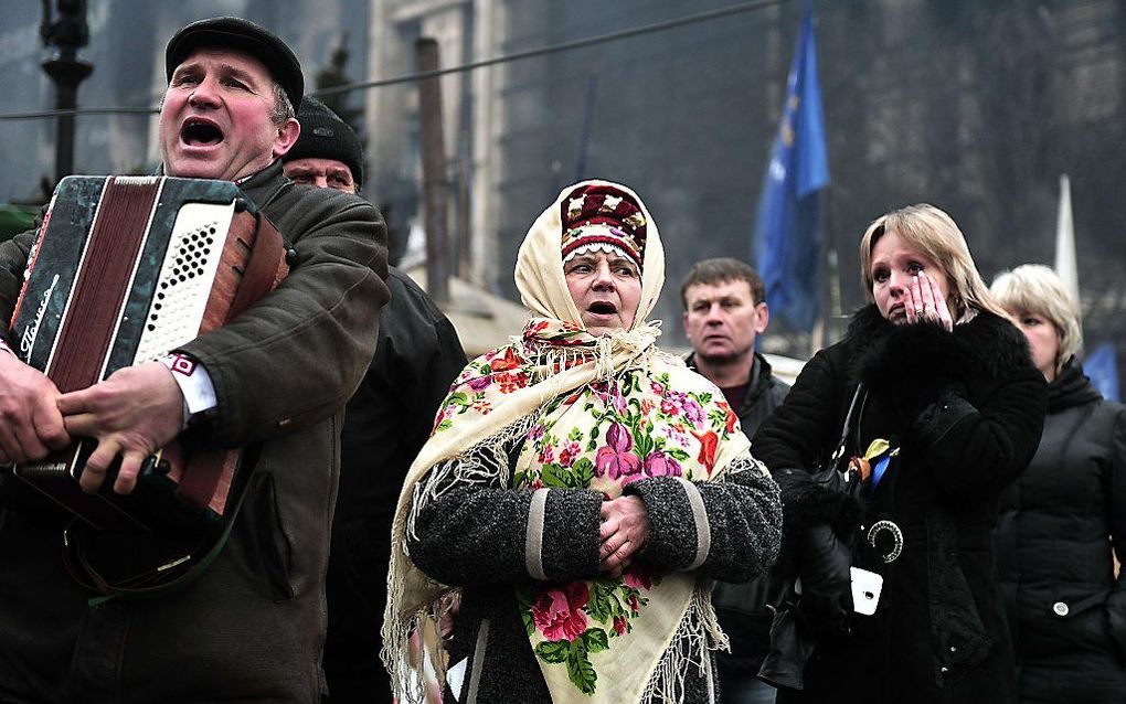 Bewoners van Kiev zingen het volkslied op het Onafhankelijkheidsplein. beeld AFP