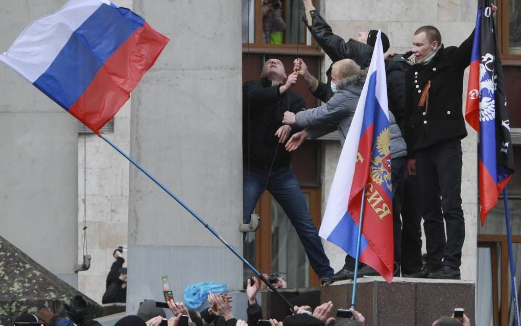 Russischgezinde demonstranten zetten een Russische vlag op het parlement van de Krim in Simferepol. foto EPA