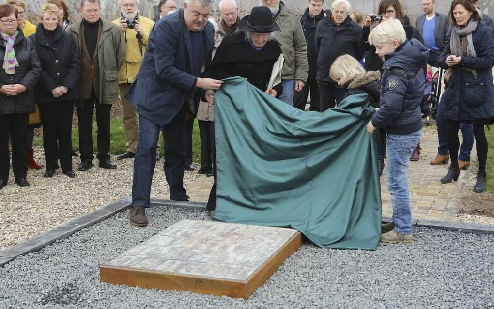 De weduwe van de overleden kunstenaar Ben Joosten en twee Dodewaardse kinderen onthullen de gedenksteen. beeld VidiPhoto