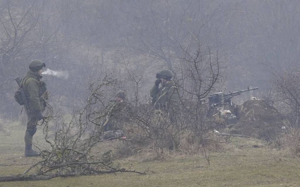 Russische militairen patrouilleren bij een Oekraïense legerbasis. foto EPA