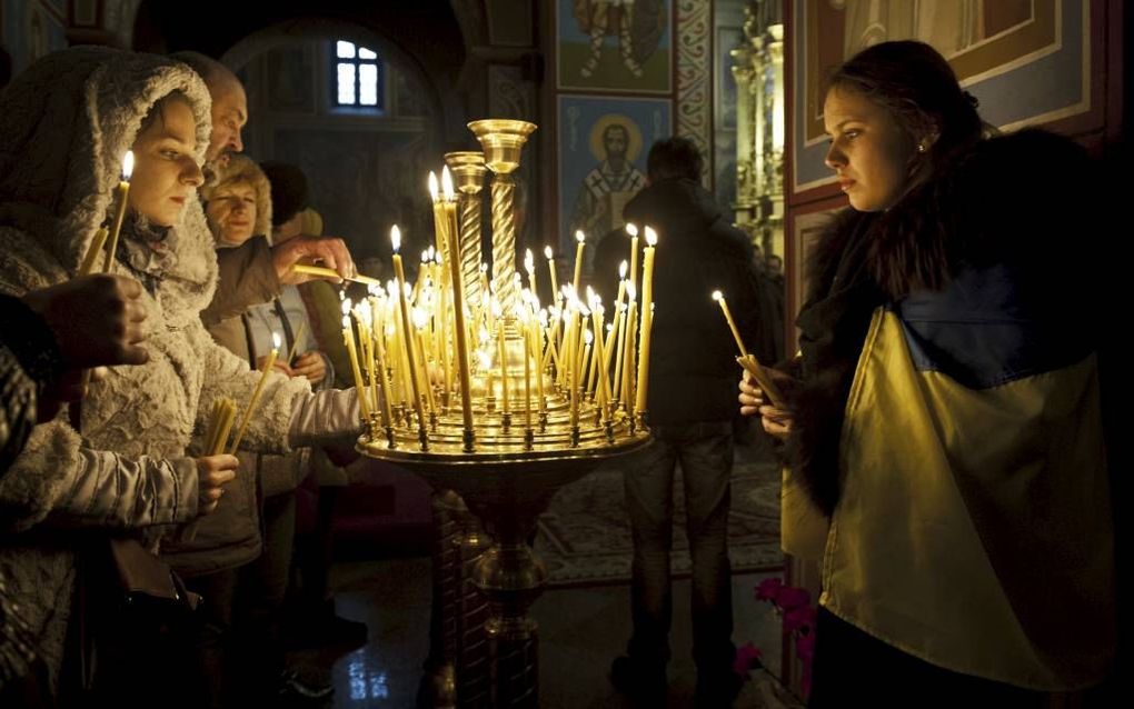 KIEV. Oekraïnse christenen branden kaarsen in een kerk in het centrum van Kiev. Vrijdag was er een vastendag in alle kerken in Oekraïne en speciale gebedsbijeenkomsten. beeld AFP