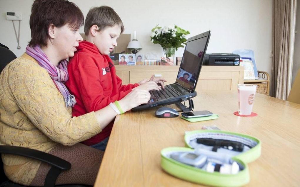 WIJNGAARDEN. Diatime-patiënt Kasper Vink (10) en zijn moeder uit Wijngaarden communiceren vanuit huis met hun behandelteam in Dordrecht. beeld Frederike Roozen-Slieker