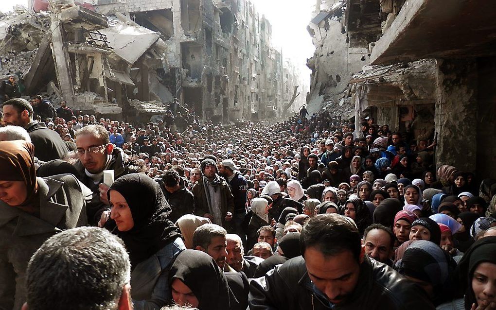 Palestijnen en Syriërs in de rij voor voedsel in het uitgehongerde kamp Yarmuk. beeld EPA