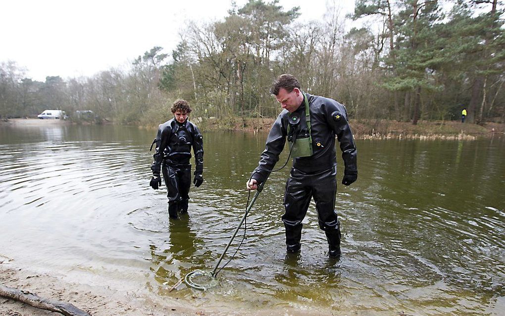 Duikers van de marine zoeken dinsdag in een vijver op het bosperceel Heidepark naast het huis van Els Borst. Ze zoeken het water af naar sporen die mogelijk meer licht kunnen werpen op het misdrijf. Foto ANP