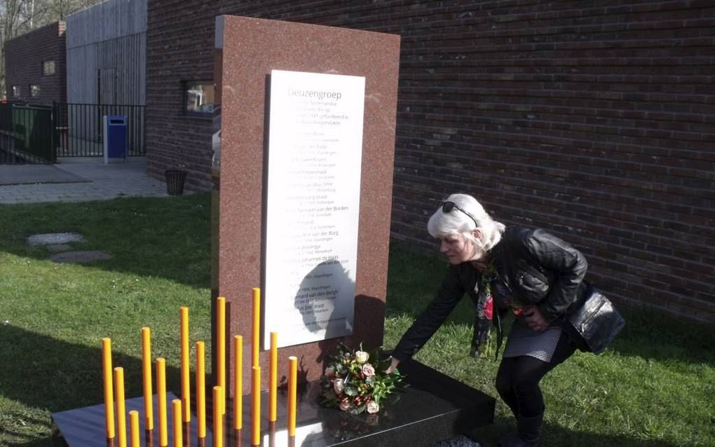 Inge van Wijk legde gisteren in Lekkerkerk bloemen bij het nieuwe monument ”Geuzengroep”, met daarop de namen van de vijftien gefusilleerde verzetsstrijders. De oranje buizen geven in centimeters hun leeftijden aan. De vader van Van Wijk werd niet gedood,