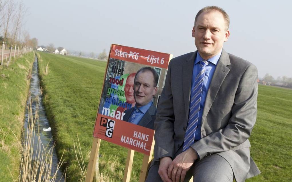 LANGBROEK. Lijsttrekker Hans Marchal van de Protestant-Christelijke Groepering in Wijk bij Duurstede bij een verkiezingsbord van zijn partij. „We willen de vrede van de stad zoeken.” beeld RD, Anton Dommerholt