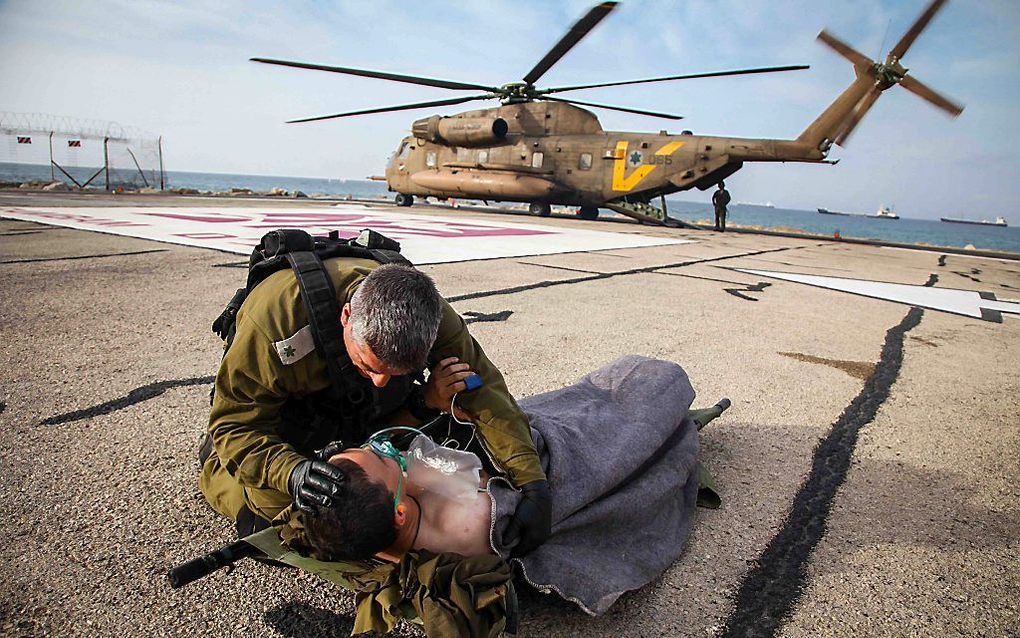 HAIFA. Een Israëlische soldaat stelt zijn gisteren door een bermbom gewond geraakte kameraad op zijn gemak. beeld EPA