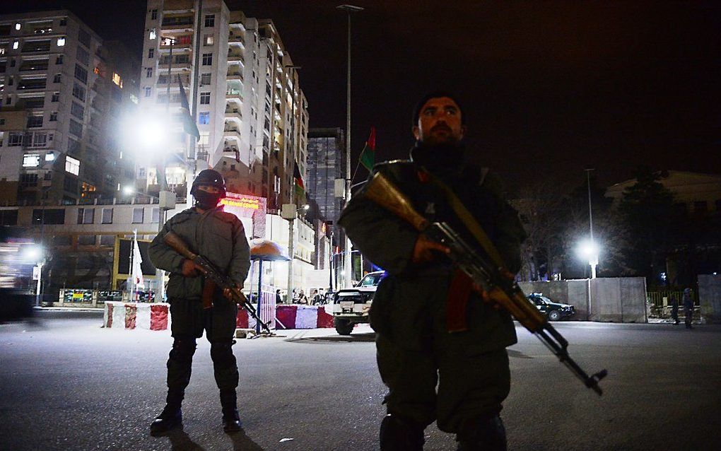 Veiligheidsagenten nabij het getroffen hotel in Kabul. Foto AFP