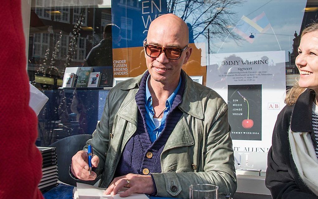 Schrijver Tommy Wieringa signeert het door hem geschreven boekenweekgeschenk. Foto ANP