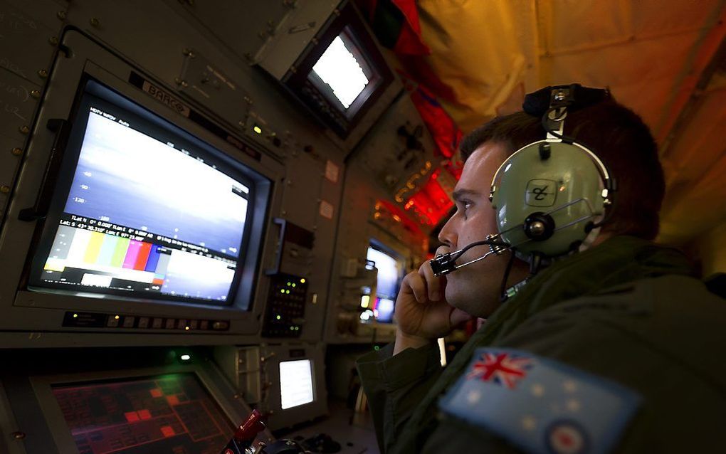 Een Australische soldaat speurt in een AP-C3 Orion vliegtuig naar sporen van Malaysia Airline MH370 boven de Indische Oceaan. Foto EPA