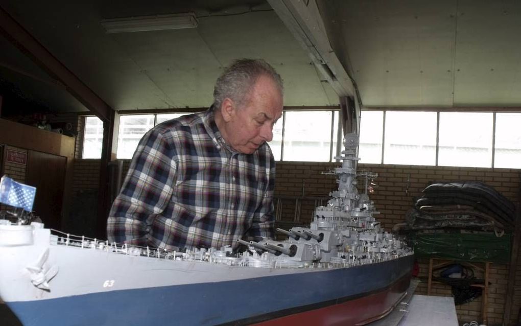 Modelschepenbouwer Hans Vollebregt bij zijn vlaggenschip USS Missouri. Vanwege de korte tijd tussen twee tentoonstellingen stalt Vollebregt het tijdelijk in een garage in plaats van op zolder. beeld Dick den Braber