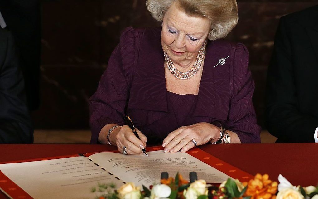 Koningin Beatrix ondertekent de Akte van Abdicatie. Foto ANP