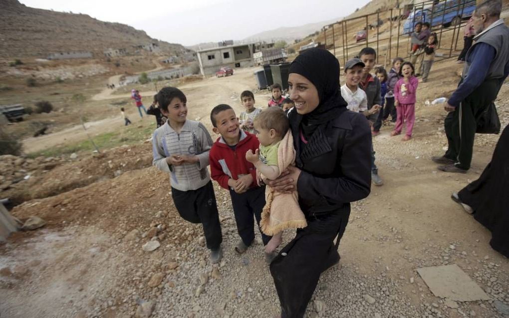 ARSAL. Een gezinnetje loopt door een vluchtelingenkamp van Syriërs in de Libanese stad Arsal. beeld AFP