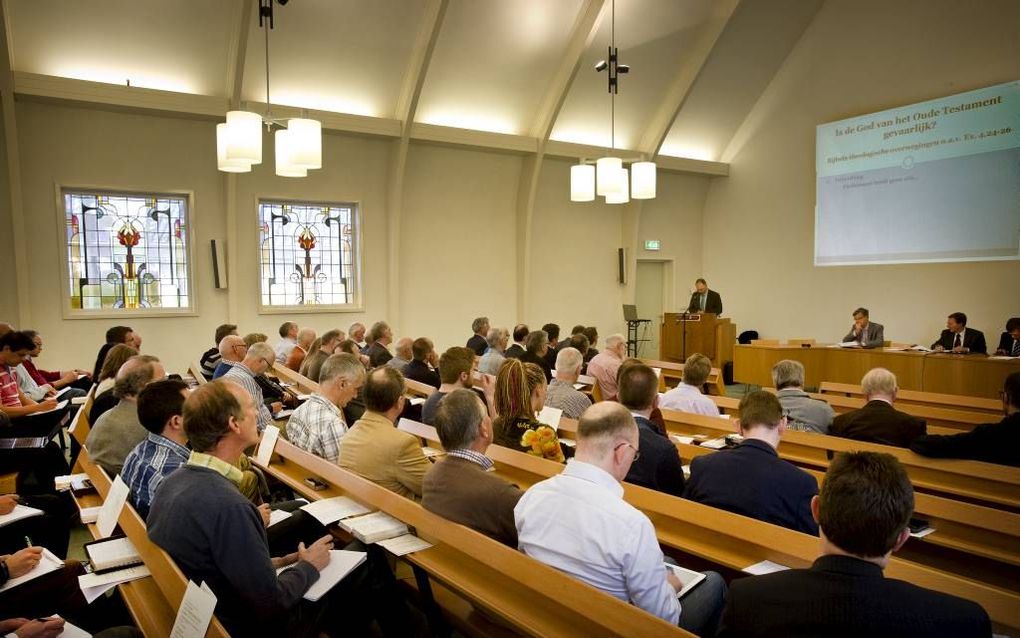 APELDOORN. Aan de Theologische Universiteit Apeldoorn had donderdag een symposium plaats rond het thema ”De God van het Oude Testament”. Foto (v.l.n.r. achter katheder en tafel): dr. J. Dekker sprak over de vraag of de God van het Oude Testament gevaarlij