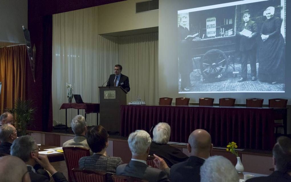 Prof. dr. Fred van Lieburg tijdens het symposium. Op het scherm ds. J. G. Verhoeff, grondlegger van de Confessionele Vereniging. beeld André Dorst