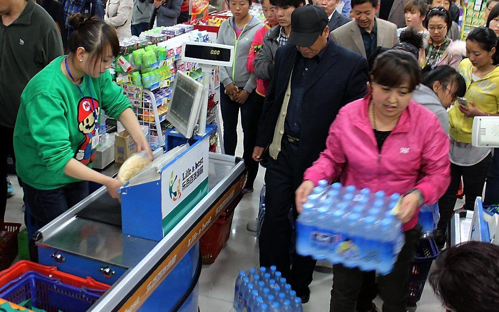 2,4 miljoen Chinezen hadden de afgelopen dagen geen drinkwater door een lek in de oliepijpleiding van een oliemaatschappij. In de supermarkten was het drinkwater snel uitverkocht. beeld AFP