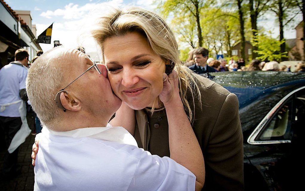 Koningin Máxima krijgt een zoen van medewerker Gerard aan het einde van haar bezoek aan Buurtmarkt Breedeweg, een supermarkt waar geestelijk beperkten samen met begeleiders werken. beeld ANP