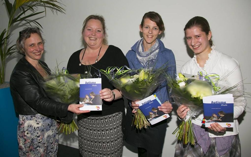 GOUDA. Maria Vermeulen van SGJ Christelijke Jeugdzorg (l.) overhandigde gisteravond de brochure ”Autisme thuis, over gezin, geloof en kerk” aan de auteurs, v.l.n.r. Lydia de Vries, Jacqueline van Gurp en Rianne Kroneman. beeld Martin Droog