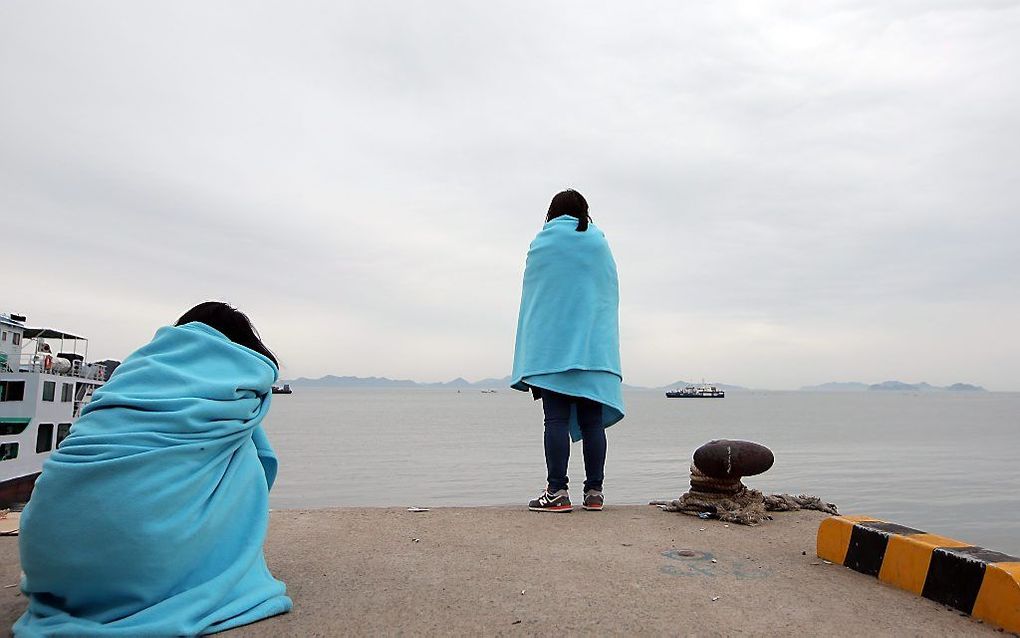 Familieleden van opvarenden van ferry Sewol staren in het water waar de boot is gezonken. Foto EPA