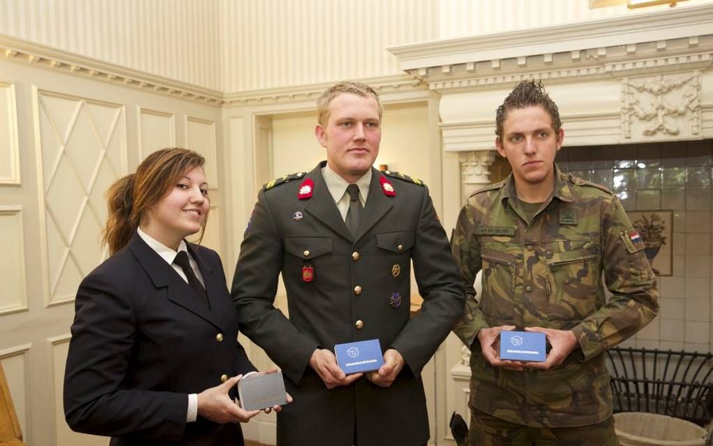 De eerste exemplaren van de nieuwe krijgsmachtbijbel werden woensdag in Hilversum uitgereikt aan (v.l.n.r.) matroos Paulette Westerbeek, korporaal Jonathan Strijbis en soldaat A. B. van der Velden. beeld Sjaak Verboom