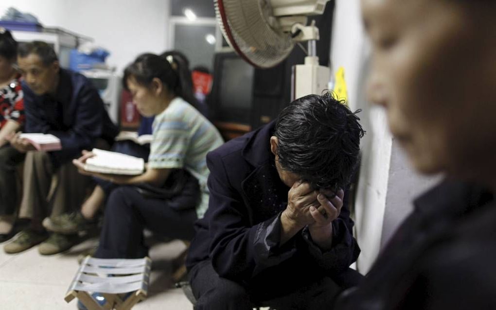 Chinese christenen, lid van een huiskerkgemeente, in gebed (2010). Beeld EPA