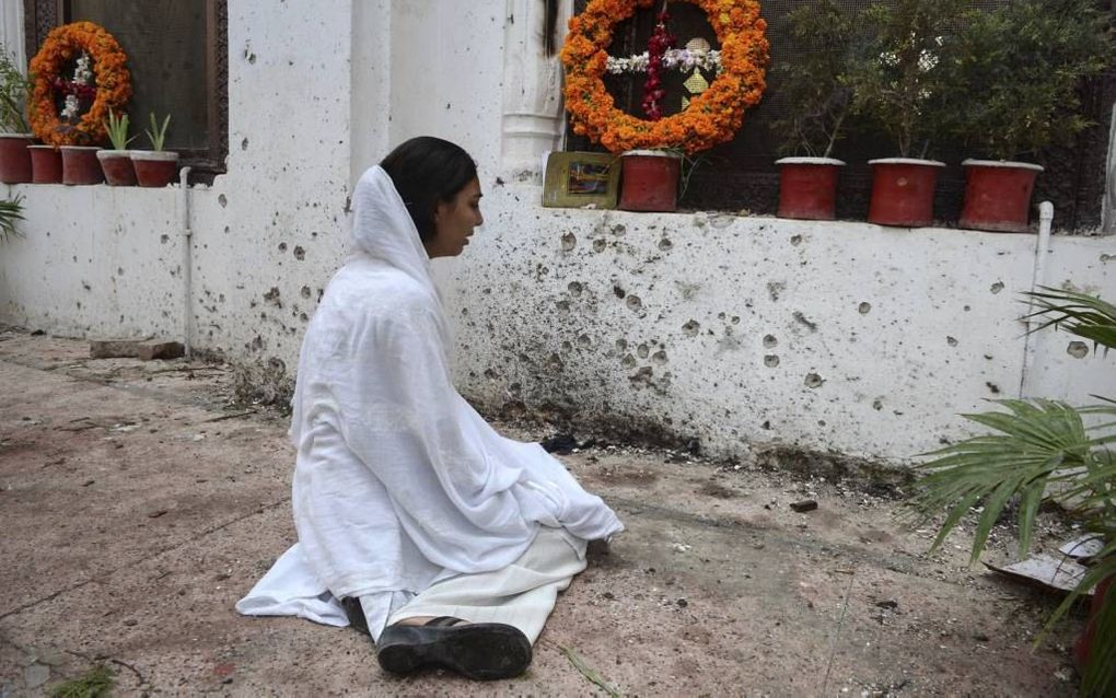 Een christelijke weduwe in Pakistan rouwt bij het graf van haar man, die bij een zelfmoordaanslag door een islamitische terrorist werd gedood. beeld ANP