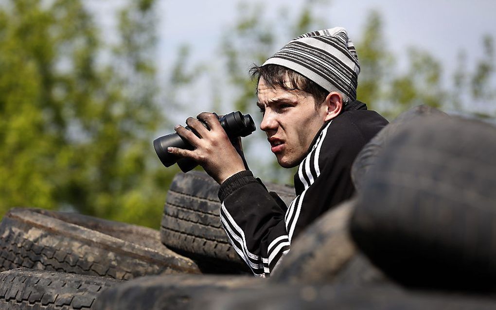 Een pro-Russische activist op de uitkijk bij een checkpoint in de buurt van Slovjansk. Foto EPA