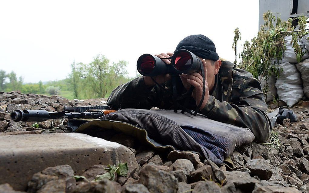 Een pro-Russische separatist bij een barricade in Slovjansk. Foto AFP