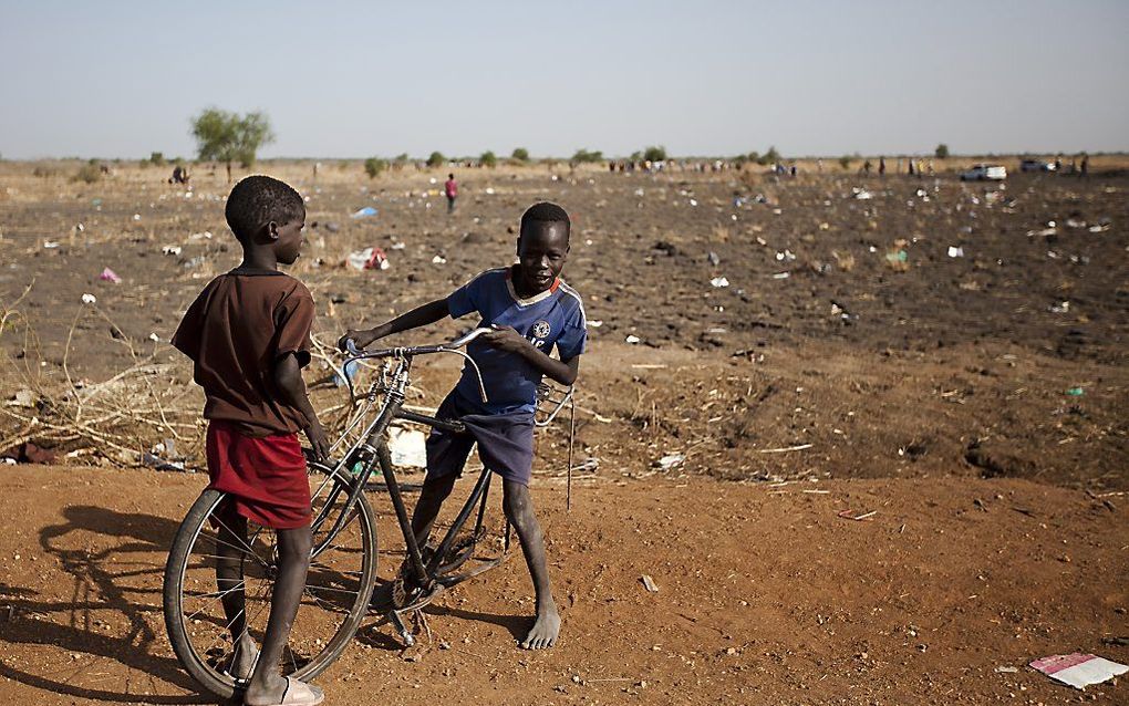 Twee jongens spelen met een kapotte fiets in de buurt van een VN-post in Zuid-Sudan. Foto AFP