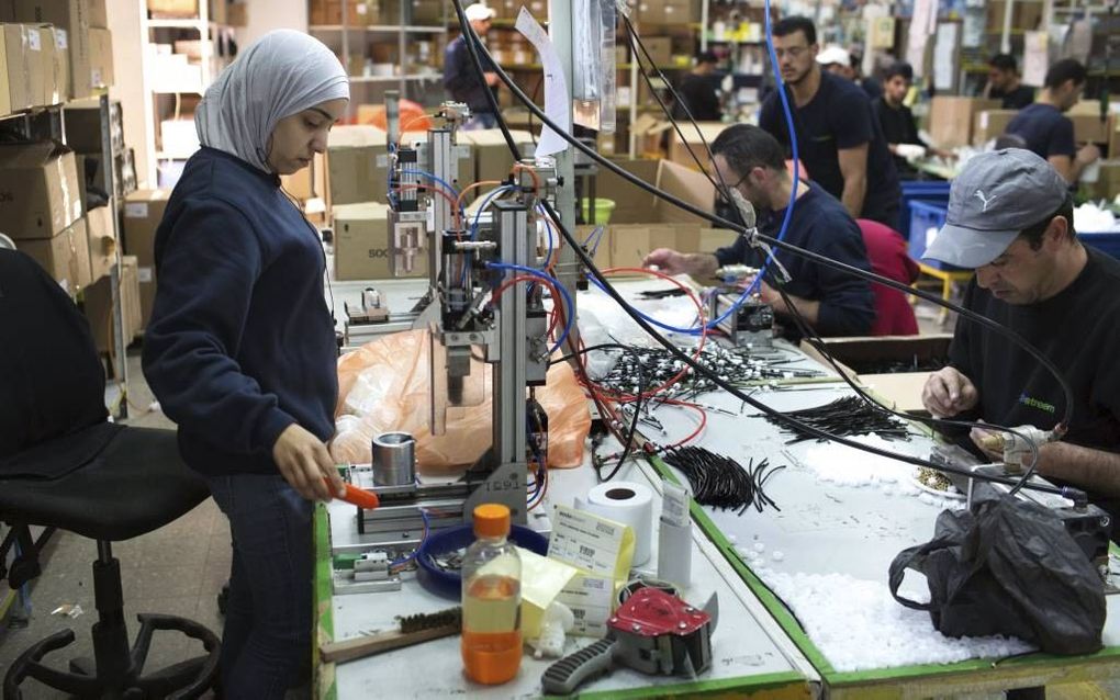 Foto: Palestijnen in de Sodastream-fabriek op de Westelijke Jordaanoever beeld AFP