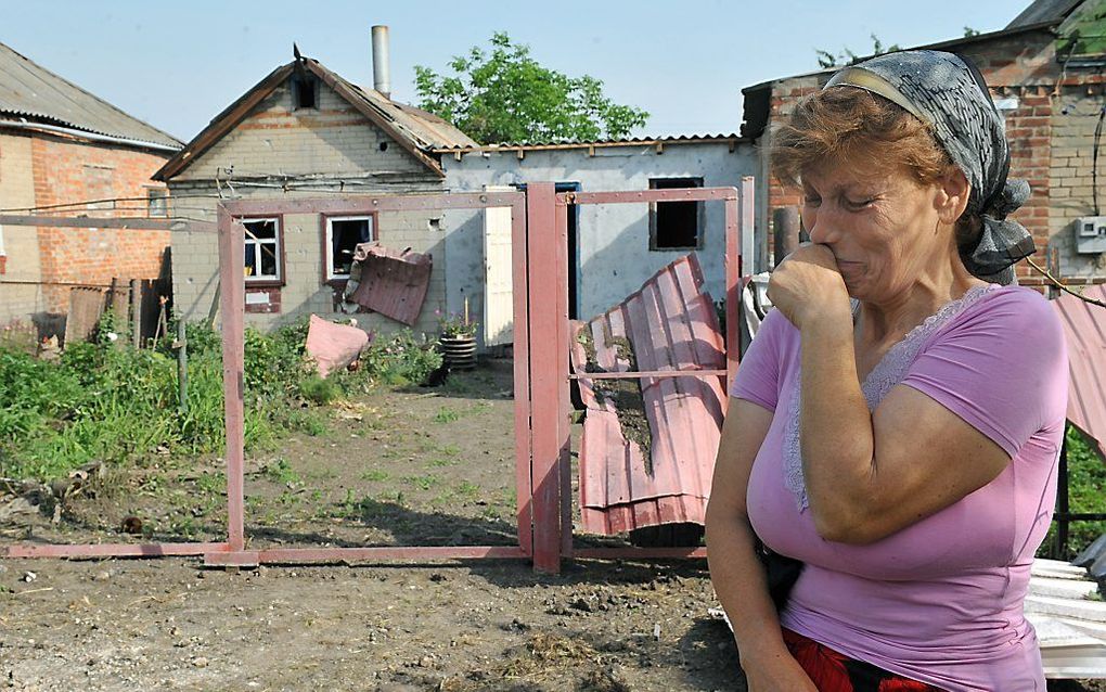 Een vrouw treurt in het oosten van Oekraïne bij de rest van haar huis. Bij gevechten is haar huis verwoest. Foto AFP