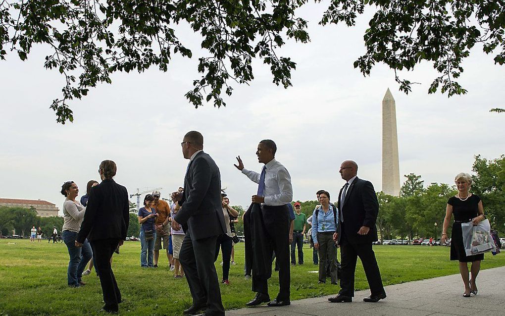 Obama zwaait naar voorbijgangers in Washington. beeld AFP